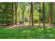 Lush green lawn surrounded by mature trees, providing a serene and private setting at 7230 Ridge Lane Rd, Charlotte, NC 28262