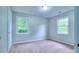 Bright, neutral bedroom with carpet and two windows offering peaceful views of surrounding greenery at 817 32Nd Street Ne Dr, Conover, NC 28613