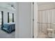 A view into a clean bedroom and bathroom, each well-lit with window and shower at 8903 Ansley Park Pl, Huntersville, NC 28078