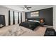 This cozy bedroom features an accent wall, a plush rug, and plenty of natural light at 8903 Ansley Park Pl, Huntersville, NC 28078
