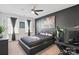 Dark themed bedroom with a large bed, fan, and modern art at 8903 Ansley Park Pl, Huntersville, NC 28078
