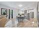 Bright breakfast nook featuring hardwood floors, a white table, and access to the kitchen and living room at 8903 Ansley Park Pl, Huntersville, NC 28078