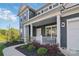 Inviting front porch with classic white columns, outdoor seating, and manicured landscaping at 8903 Ansley Park Pl, Huntersville, NC 28078