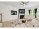 Bright living room with a fireplace, ceiling fan, and tan sofas at 8903 Ansley Park Pl, Huntersville, NC 28078