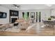 Bright living room featuring a fireplace, hardwood floors, neutral paint, and access to the breakfast nook at 8903 Ansley Park Pl, Huntersville, NC 28078