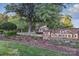 Stone signage for Olmsted with flower beds and a glimpse of the community's architecture at 8903 Ansley Park Pl, Huntersville, NC 28078