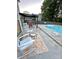 Cozy backyard patio with white rocking chairs, a pool, an outdoor dining set, and a pergola at 9003 Brad Ct, Matthews, NC 28104