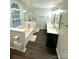 This bathroom features dual sinks, a soaking tub, a glass enclosed shower, and wood floors at 9003 Brad Ct, Matthews, NC 28104