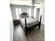 This bedroom boasts wood floors, natural light, and a stylish canopy bed at 9003 Brad Ct, Matthews, NC 28104