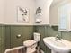 Charming powder room features green wainscoting, modern fixtures, and stylish decor at 10035 Mast Cove Ln, Charlotte, NC 28278