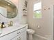 Elegant bathroom featuring a round mirror, stylish vanity and decor shelving at 10035 Mast Cove Ln, Charlotte, NC 28278