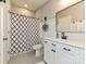 Well-lit bathroom featuring a shower with blue-patterned curtain and vanity at 10035 Mast Cove Ln, Charlotte, NC 28278