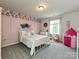This vibrant bedroom features a pink accent wall, soft carpet, and decor at 10035 Mast Cove Ln, Charlotte, NC 28278