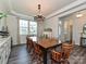 Spacious dining room showcases a large table, chandelier, hardwood floors, and natural light at 10035 Mast Cove Ln, Charlotte, NC 28278