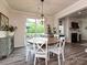 Dining room with a round wooden table, white chairs, modern chandelier, and sliding door to the outdoor patio at 10035 Mast Cove Ln, Charlotte, NC 28278