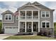 Charming two-story home with an inviting front porch, stone accents, and a well-manicured lawn at 10035 Mast Cove Ln, Charlotte, NC 28278