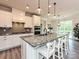 Bright kitchen with white cabinets, a granite island, and a view of the dining area with patio access at 10035 Mast Cove Ln, Charlotte, NC 28278