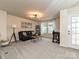 Comfortable living room is illuminated by natural light and features a contemporary design and plush carpeting at 10035 Mast Cove Ln, Charlotte, NC 28278
