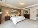 This spacious bedroom features neutral walls, soft carpet, decorative artwork, and a comfortable-looking king-sized bed at 10035 Mast Cove Ln, Charlotte, NC 28278