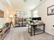 Bright office space featuring a modern desk setup, shelving, and decorative wall art at 10035 Mast Cove Ln, Charlotte, NC 28278