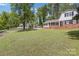 Charming brick home with black shutters surrounded by lush green lawn and mature trees at 101 Grier St, York, SC 29745