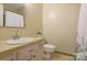 This quaint bathroom includes a vanity, toilet, and tiled shower at 101 Grier St, York, SC 29745