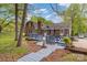 Charming brick home with a wooden deck, surrounded by lush greenery and mature trees at 101 Grier St, York, SC 29745
