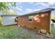 Red brick ranch home with a single window and door, situated on a grassy lot with a small shed attached at 1131 Laurel St, Salisbury, NC 28144