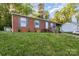 Cozy brick home with neat landscaping, highlighted by gray shutters and a convenient front entrance with welcoming sign at 1131 Laurel St, Salisbury, NC 28144