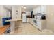 A well-lit kitchen boasts white appliances, a tiled floor, a breakfast bar and lots of cabinet space at 1131 Laurel St, Salisbury, NC 28144