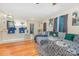 Comfortable living room featuring a large gray sofa, hardwood floors, and a view into the kitchen area at 1131 Laurel St, Salisbury, NC 28144