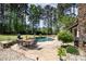 An inviting backyard with a pool, patio, outdoor dining area, and a view of the lush greenery at 114 Misty Meadows Ct, Mooresville, NC 28117