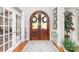 Elegant foyer with a wooden arched double door, hardwood floors, and a decorative rug at 114 Misty Meadows Ct, Mooresville, NC 28117