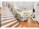 Bright living room features a stone fireplace, hardwood floors, and elegant staircase at 114 Misty Meadows Ct, Mooresville, NC 28117