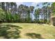 Expansive backyard with lush green grass, mature trees, and distant view of the patio at 114 Misty Meadows Ct, Mooresville, NC 28117