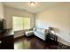 Bedroom with a modern gray sofa, dark wood floors, and a window for natural light at 12421 Fiorentina St, Charlotte, NC 28277