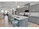 Bright kitchen with large island, seating, stainless appliances, pendant lighting, and gray cabinets at 138 Marron Dr # 25, Indian Trail, NC 28079