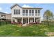 Back exterior of house with a covered patio and landscaped backyard at 140 Sisters Cove Ct, Mooresville, NC 28117