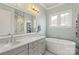 Bright bathroom with dual vanity, soaker tub, and large mirror at 140 Sisters Cove Ct, Mooresville, NC 28117