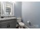 Elegant half bathroom featuring granite countertop and gray vanity at 140 Sisters Cove Ct, Mooresville, NC 28117