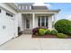 Inviting home entrance with a covered porch, well-kept landscaping, and an attached two-car garage at 140 Sisters Cove Ct, Mooresville, NC 28117