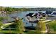 An eye-level exterior view of a lakeside home with lush landscaping and mature trees at 140 Sisters Cove Ct, Mooresville, NC 28117