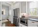 Bright kitchen features modern stainless-steel appliances, white cabinets and trim, with hardwood floors and recessed lighting at 140 Sisters Cove Ct, Mooresville, NC 28117