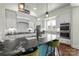 A gourmet kitchen features an island with a black marble countertop, white cabinets, and modern appliances at 140 Sisters Cove Ct, Mooresville, NC 28117