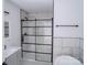 A bathroom features a standing shower, a sink, and marble-style tile at 1413 Hateras Ave, Charlotte, NC 28216