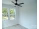 A bright bedroom features a ceiling fan and large windows providing ample natural light at 1413 Hateras Ave, Charlotte, NC 28216