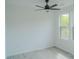 Minimalist bedroom with neutral paint, ceiling fan and large windows at 1413 Hateras Ave, Charlotte, NC 28216