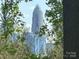 Framed view of a modern skyscraper through trees in a natural setting at 1413 Hateras Ave, Charlotte, NC 28216