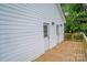 Newly built home featuring a wooden deck, white siding, two doors, and black outdoor lights at 1413 Hateras Ave, Charlotte, NC 28216