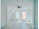 Open living room boasts a ceiling fan, with stairs, and natural light from two windows at 1413 Hateras Ave, Charlotte, NC 28216
